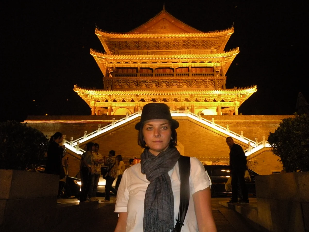 Erika pred osvetlenou bránou – nočný Xi’an, Čína