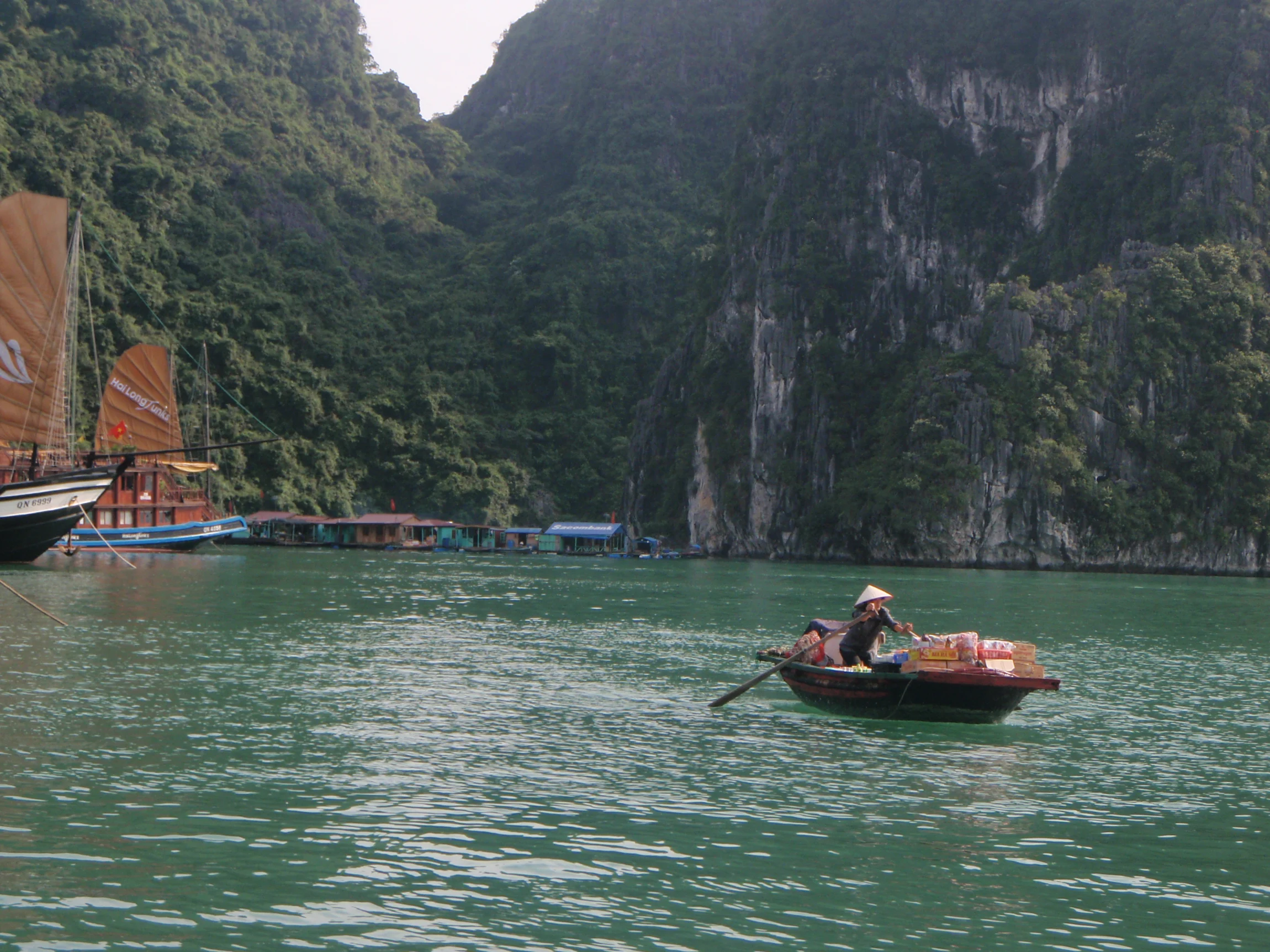 Osamelá loďka medzi skalami – Halong Bay, Vietnam