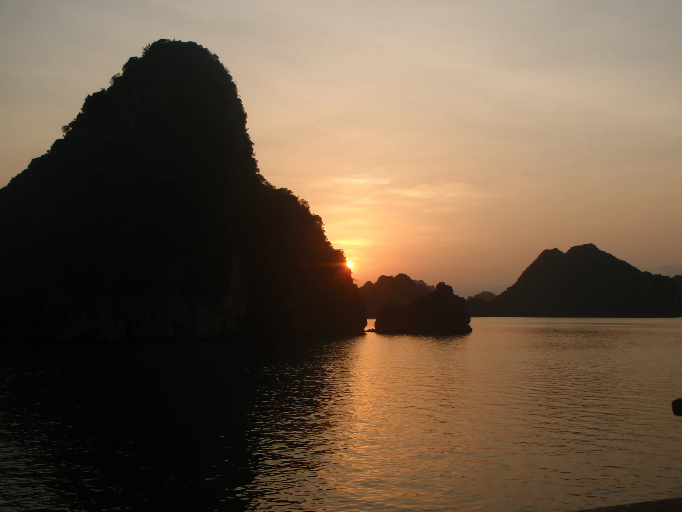 Západ slnka medzi vápencovými skalami – Halong Bay